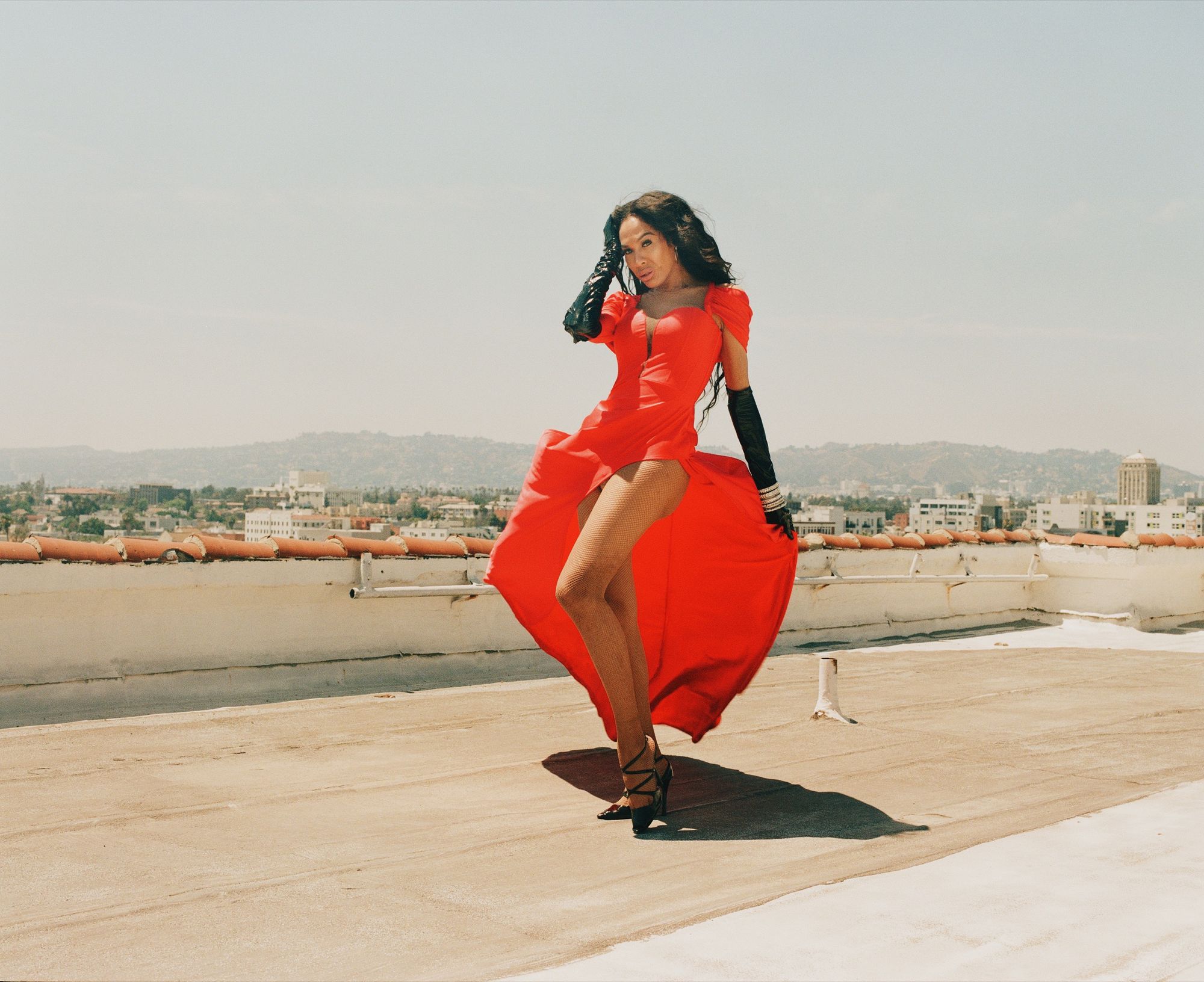 Gia Banks posing on rooftop in red dress (photography by Texas Isaiah)