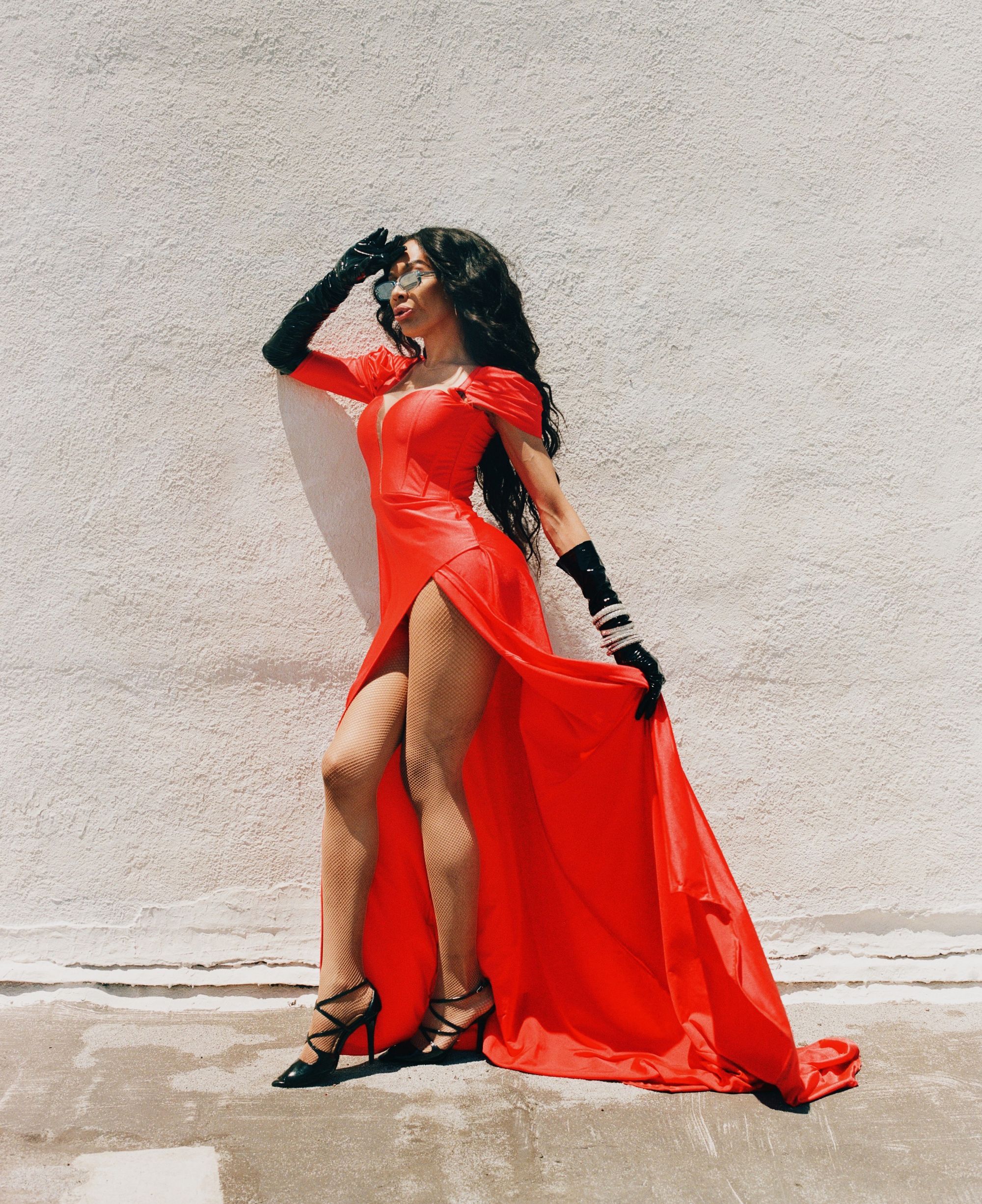 Gia Banks posing in front of white wall wearing red dress (photography by Texas-Isaiah)